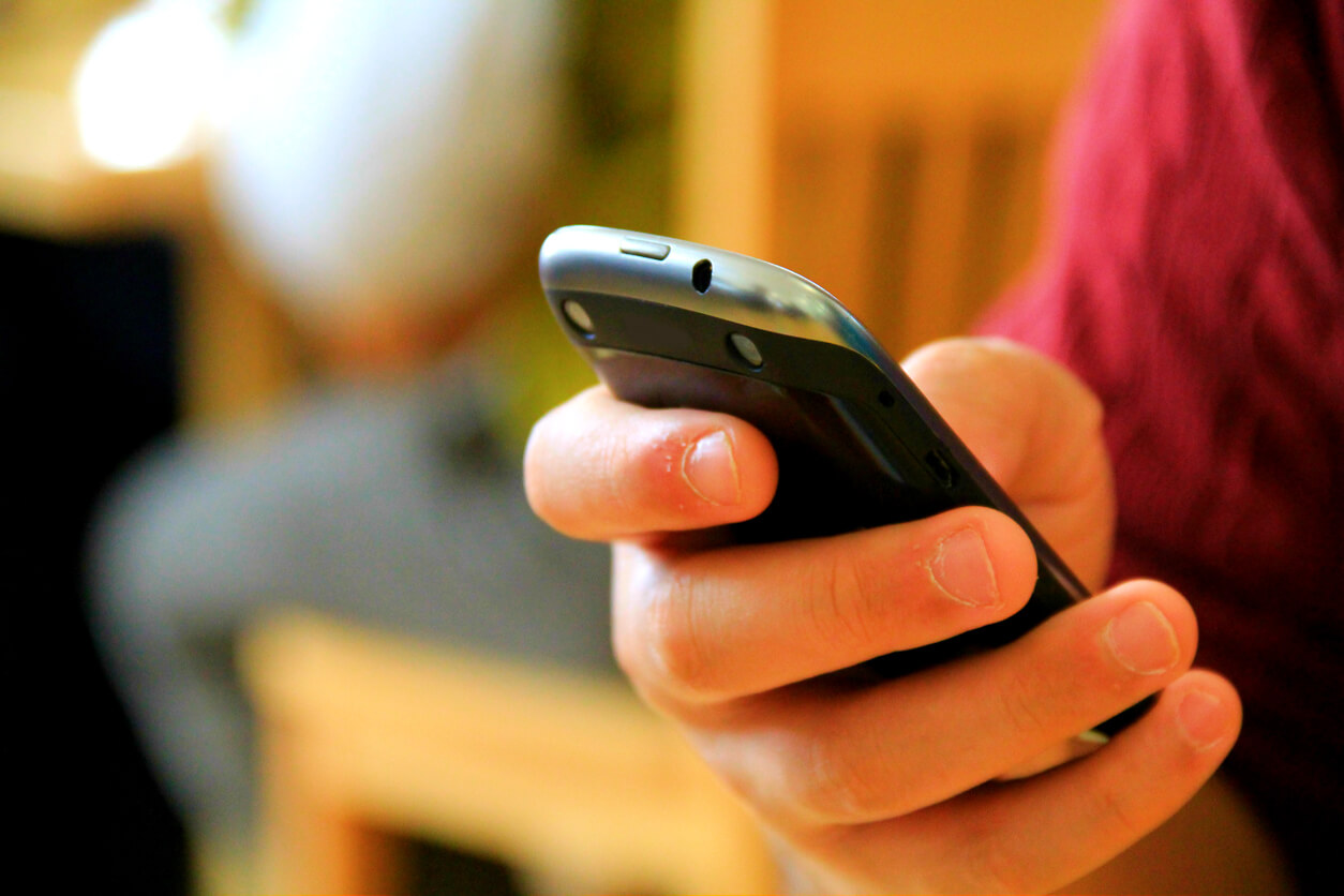 Hand Holding A Black Smart Phone